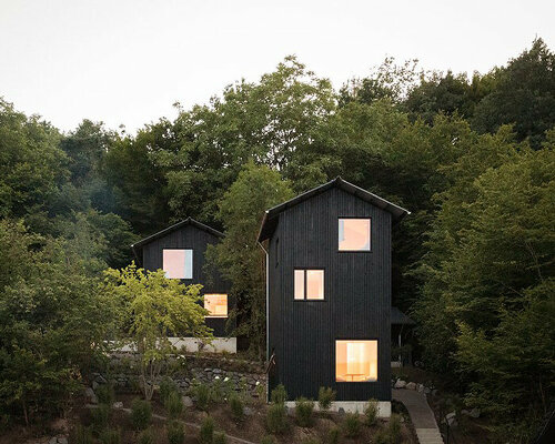 dark timber holiday cabins immerse guests in the stillness of remote german forest