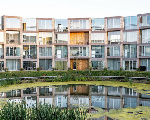 BIG's modular housing spirals around central pond in danish sustainable suburb