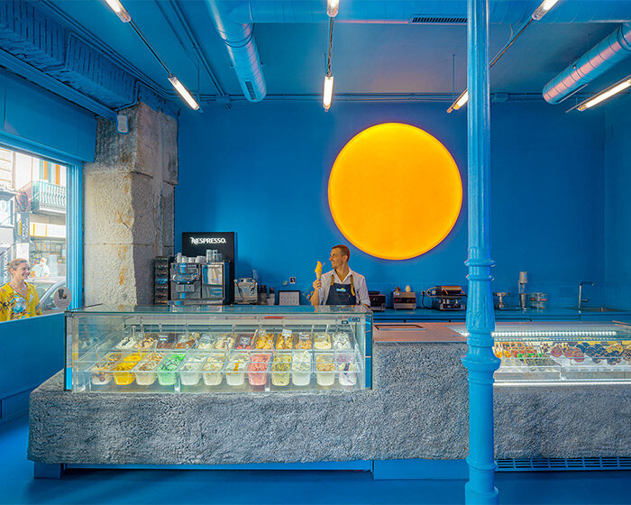 luminous 'sun' lamp brightens all-blue ice cream shop interior in madrid, spain