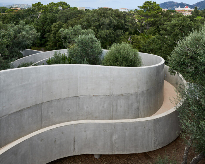 animu media library's concrete curves embrace the site's existing landscape in porto-vecchio