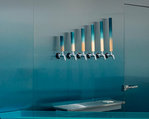 gradient blue walk-in fridge lined with beer taps floats in white interior of taproom in tokyo