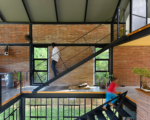 repurposed factory tiles and pivoted glazing define permeable residence in india