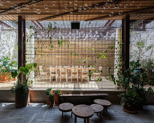 rustic mexican restaurant engulfs diners with metallic mesh net woven with lush greenery