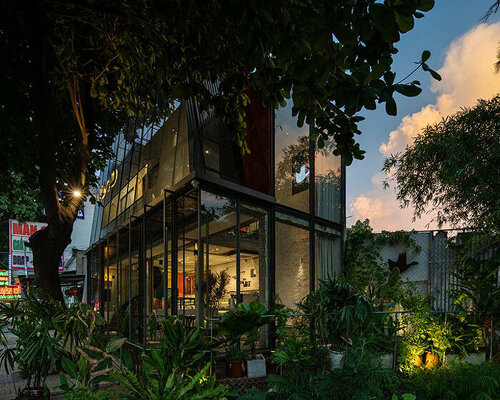 A+H architects wraps vietnam café with large, rotating glass doors + perforated steel panels