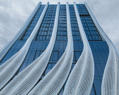 perforated calligraphic panels clad mix-use tower emerging from mumbai’s cityscape