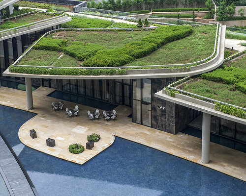 overlapping green roofs enclose this 'camellias' wellness club in india