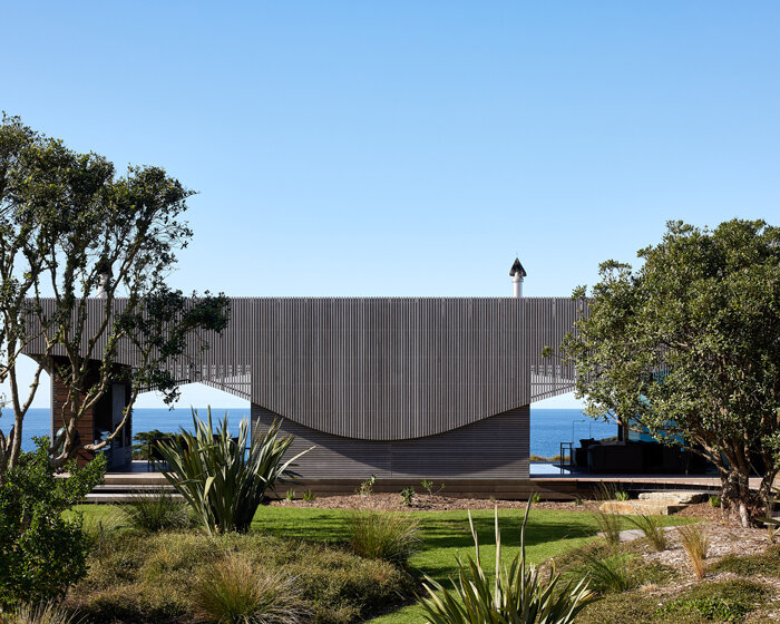 herbst architects nestles this softly curving house into the new zealand dunes