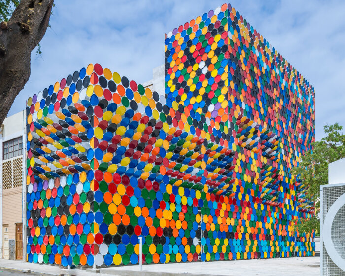 reversible rainbow barrel lids jazz up facade of national arts center building in cape verde