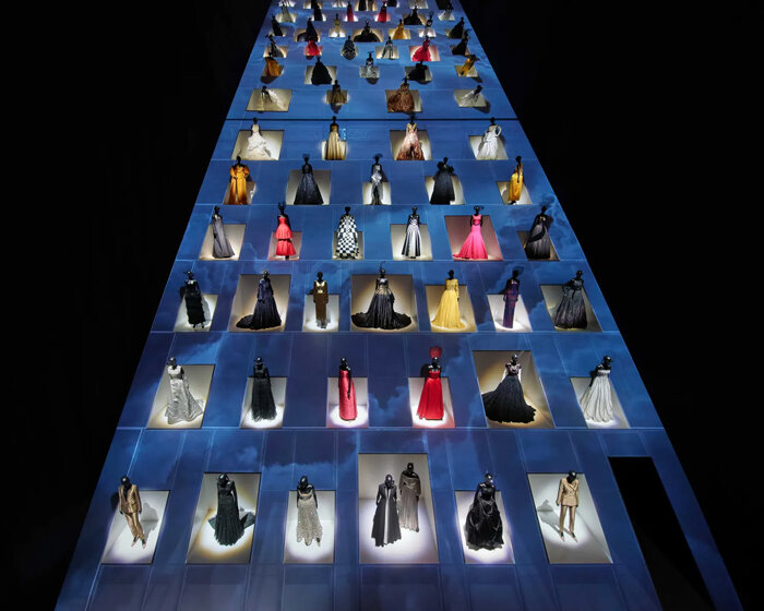 mannequins in gowns climb up a giant slope in OMA-designed dior exhibition in tokyo