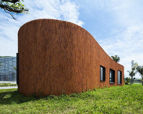 a vivid brick shell envelops inrestudio's bean-shaped laboratory in vietnam