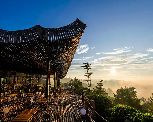 perforated wooden roof drapes over outdoor café in vietnamese rural landscape