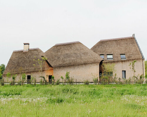 LMNL office tops brick house with fragmented thatched roof in the netherlands