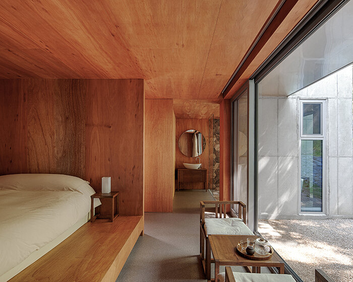 a minimalist retreat is nestled beneath the wooded mountains of korea