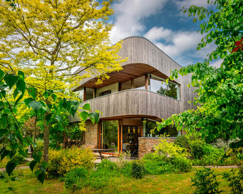 dynamic curved wooden volumes render camping villa's organic outline in amsterdam