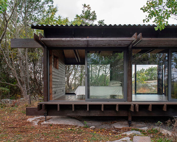 a grid of stained dark planks shapes up wooden cabin in west sweden