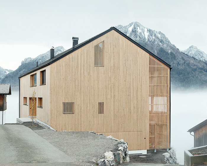 slender wooden slabs enclose permeable facade for 'multigenerational house' in rural austria