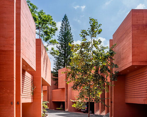 orange-tinted concrete blocks subtly stack residential complex in mexico