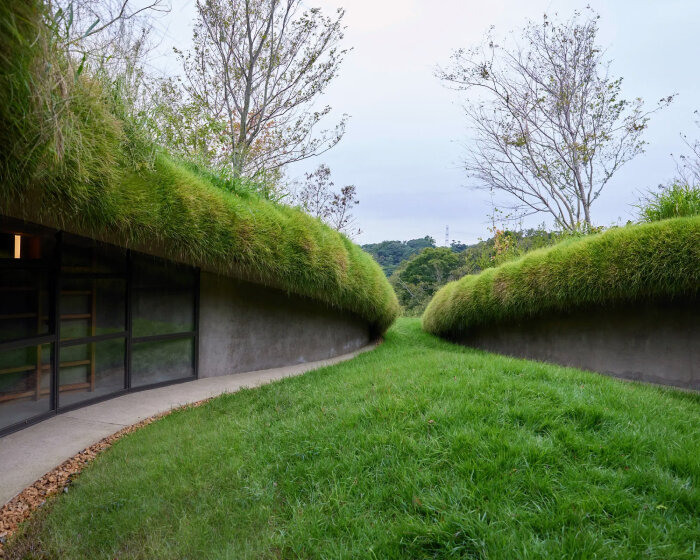 underground library in japan’s kurkku fields invites bookworms in a cavern-like reading space