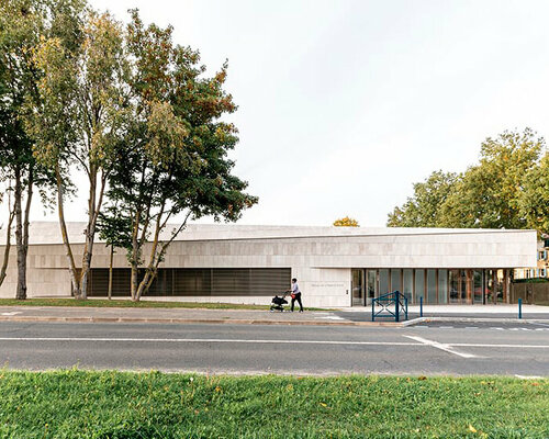 sloping roof of stone slates softly inserts nursery school into the parisian landscape