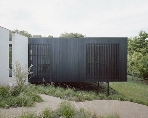 masonry blade walls & a floating timber volume compose 'peninsula house' in australia