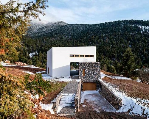 icy white volume overlays stone-built 'snowfall house' in greece