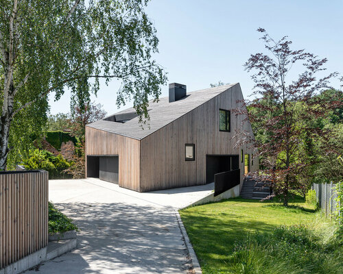 fragmented residence wraps in raw larch slats in polish countryside