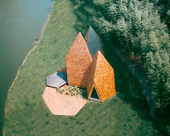 wooden shingles overlay cluster of monolithic cabins on chinese waterfront