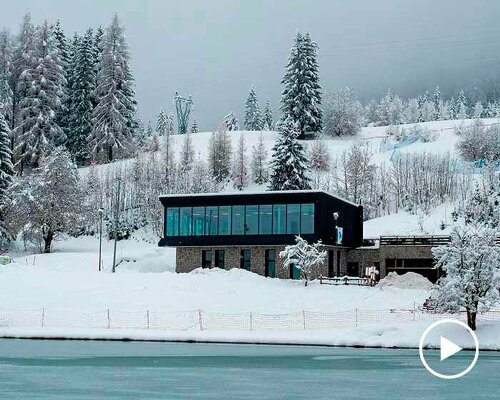 ski center's black metal skin contrasts the white alpine landscape of tarvisio