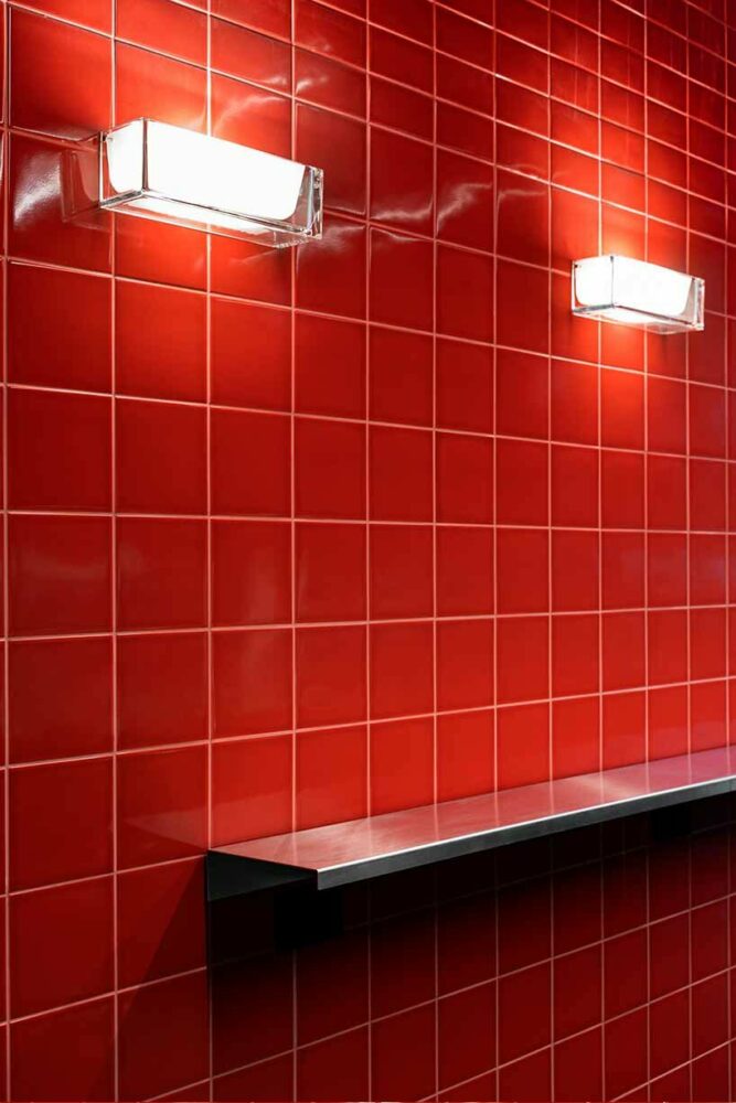 glossy red tiles contrast with lime green counter within spazio maiocchi’s new bar in milan