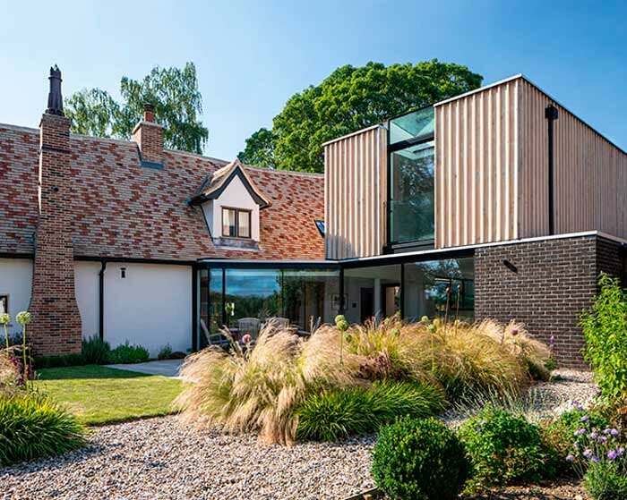 vertical oak cladded formation expands 17th-century renovated cottage in the UK