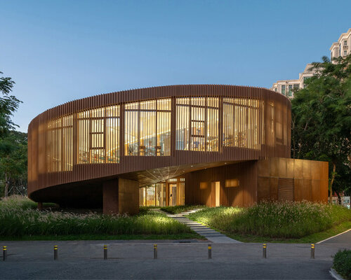 atelier xi's spiraling bookhouse frames scenic views of a riverside park in shenzhen