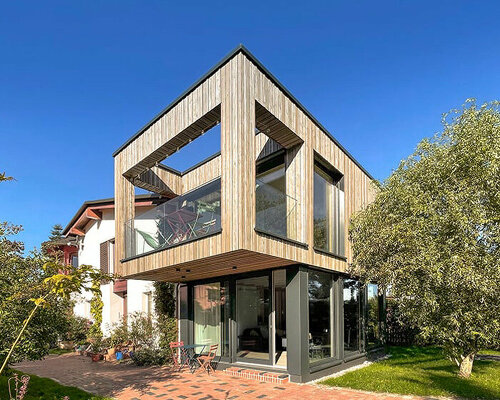 german home's cantilevering annex and natural tones invite the outdoors in