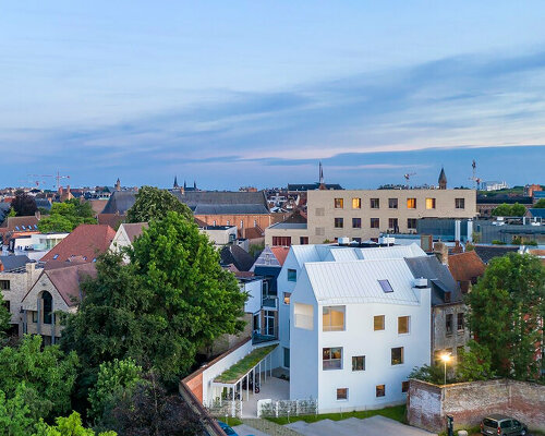 white gabled houses by dmvA integrate with the historic urban fabric of belgium