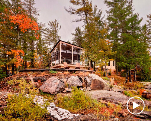 wooden cottage's jagged overhangs hover above lake landscape in canada