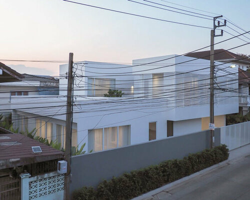 translucent volumes encircle a core courtyard at this multi-generational home in bangkok