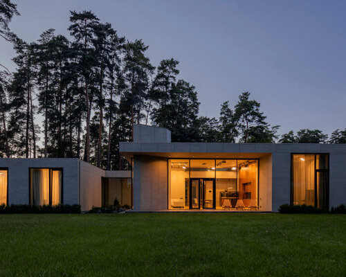 concrete residence in latvia unfolds two distinct volumes with dynamic cantilevers