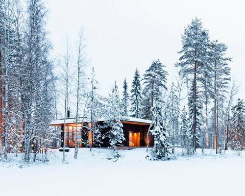 ecological wooden cabin nestles in rural finland's lakeside setting