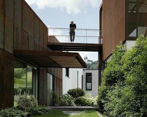 a trio of rusted steel volumes forms this 'deconstructed house' in austria