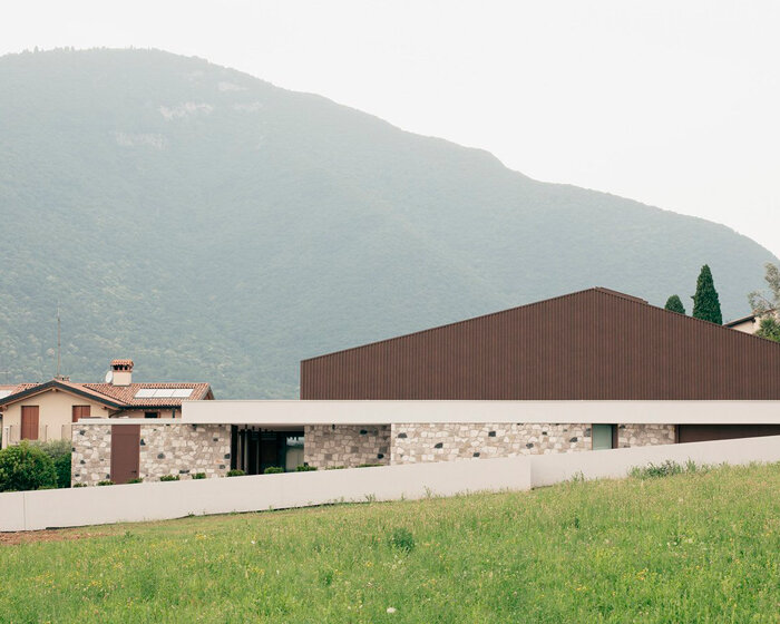 stone walls and warm wooden features adorn private residence in northern italy