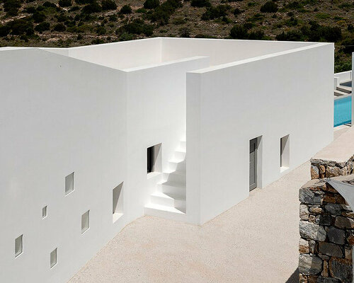 riza house's whitewashed walls emerge from arid greek landscape