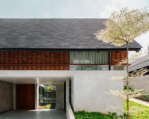 red brick lace-like facade coats the mass of ach house in south jakarta