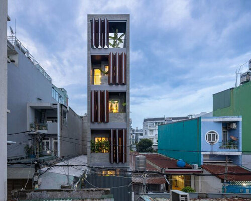 folding teak shutters weave light and nature into pham trung's narrow home in vietnam