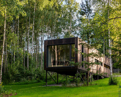 kirill skorynin’s prefabricated modular house perches on stilts to preserve its natural terrain