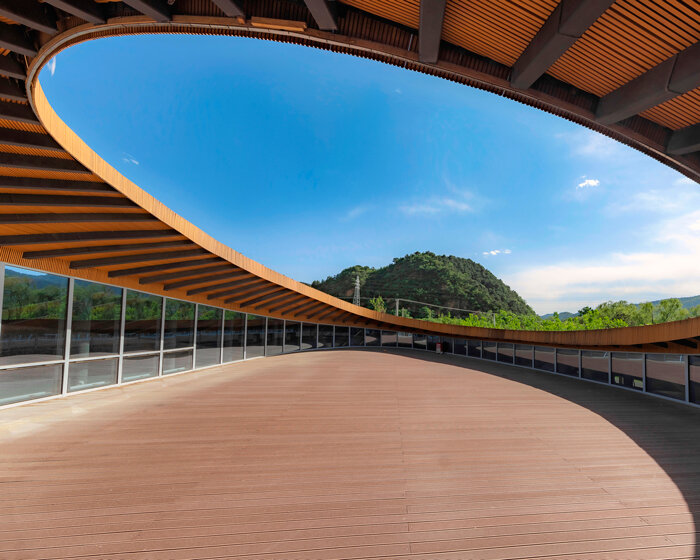 sculptural roof informs the ring-shaped design of lake education center in china