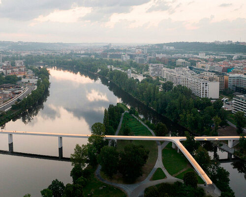 sleek concrete pedestrian bridge spans the vltava river in prague