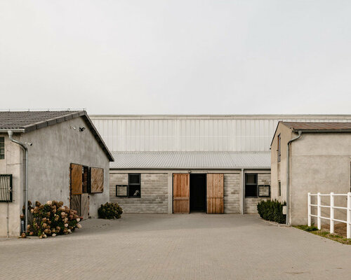 raw concrete, steel panels, and wood wrap wiercinski studio's equestrian center in poland