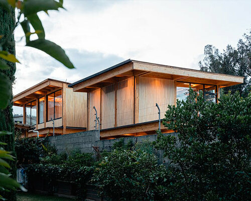 two identical wooden blocks form a mirroring c-shape residence in ecuador