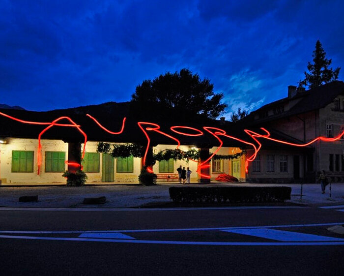 moradavaga's neon red light installation envelops former train station in italy