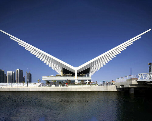 a curving steel finned roof extends over AMA's dubai harbour yacht club