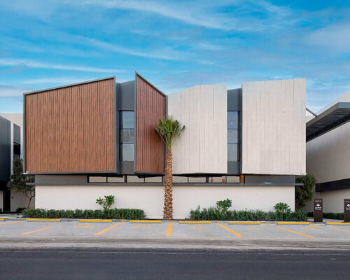 a series of timber-clad and concrete boxes compose courtyard houses in saudi arabia